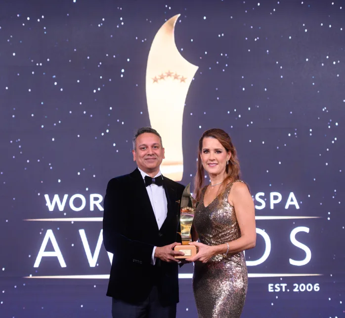 Ein Mann im Smoking nimmt bei einer Preisverleihung eine goldene Trophäe entgegen