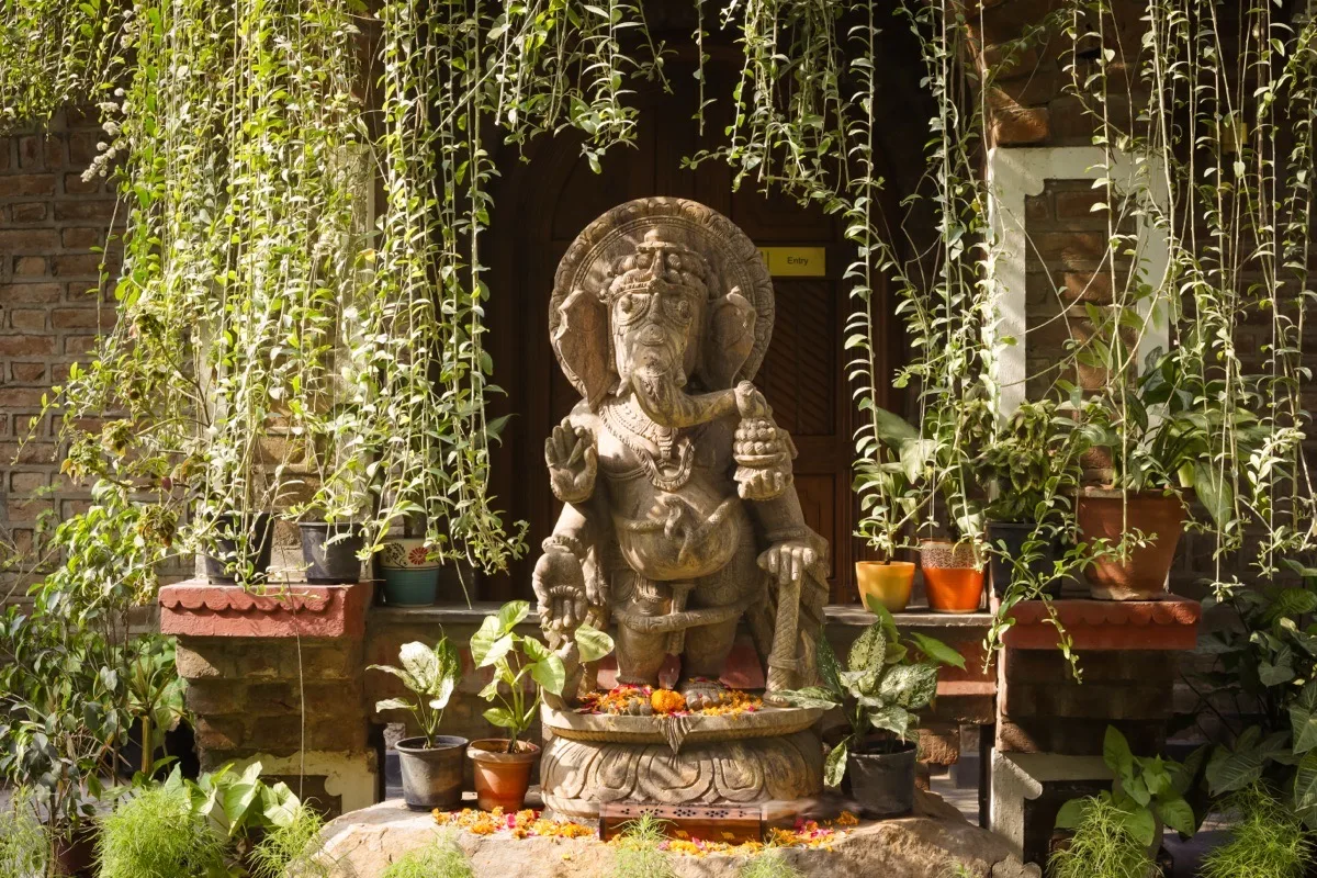 Ganesha statue at the Kairali entrance surrounded by medicinal greenery